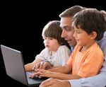 Teacher and two young children learning together on a laptop, representing digital learning in child care settings.