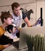 Two young people and a bulldog looking at a laptop screen with a modern map background, showcasing online engagement.